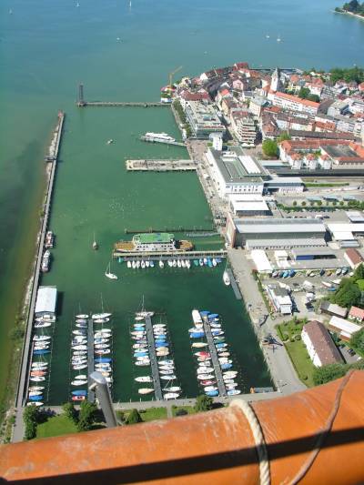Blick aus dem Ballonkorb auf den Hafen von Friedrichshafen. Vorne befindet sich der Yachthafen, dahinter die Fähranleger. Rechts zwischen dem Hafenbecken und dem Hafenbahnhof das Zeppelin-Museum